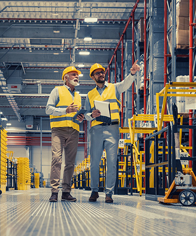 Two e-commerce workers wearing PPE in a warehouse